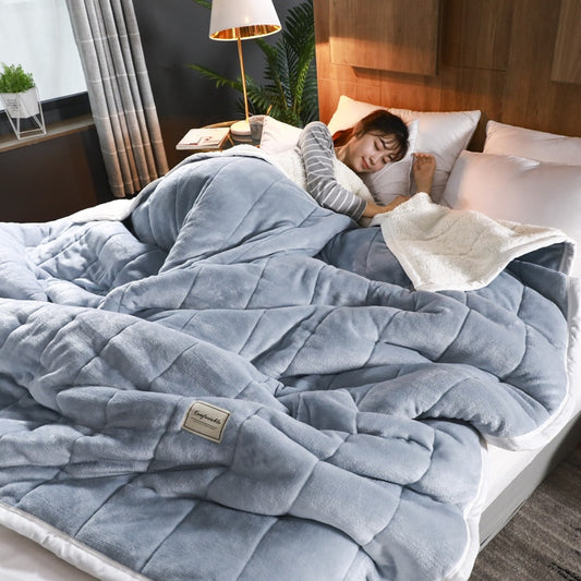Luxury fleece throw blanket draped over a bed with a woman sleeping comfortably underneath.