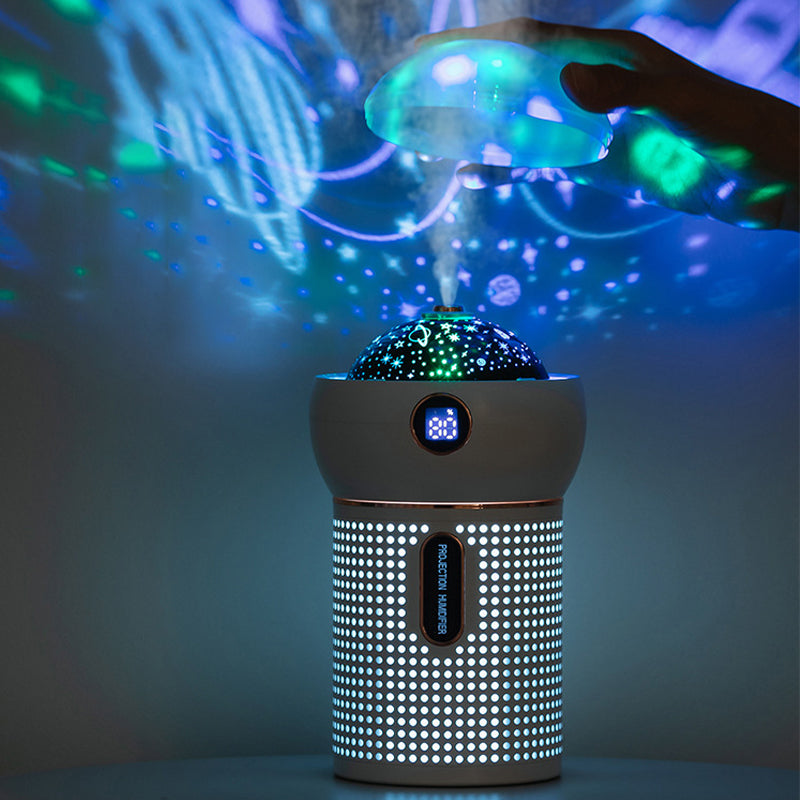 Projection night light humidifier with colorful projections and mist in a dark room.